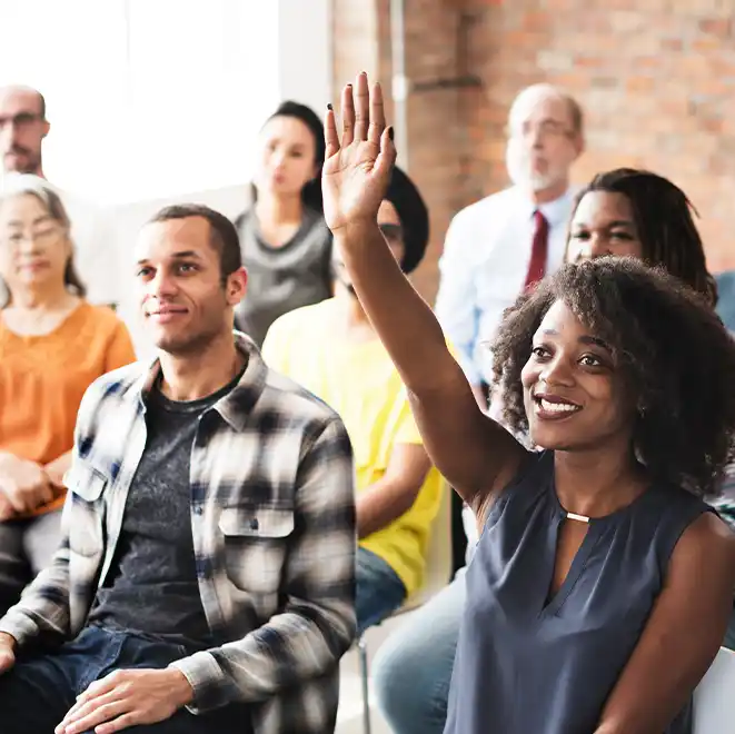woman raising hand to volunteer